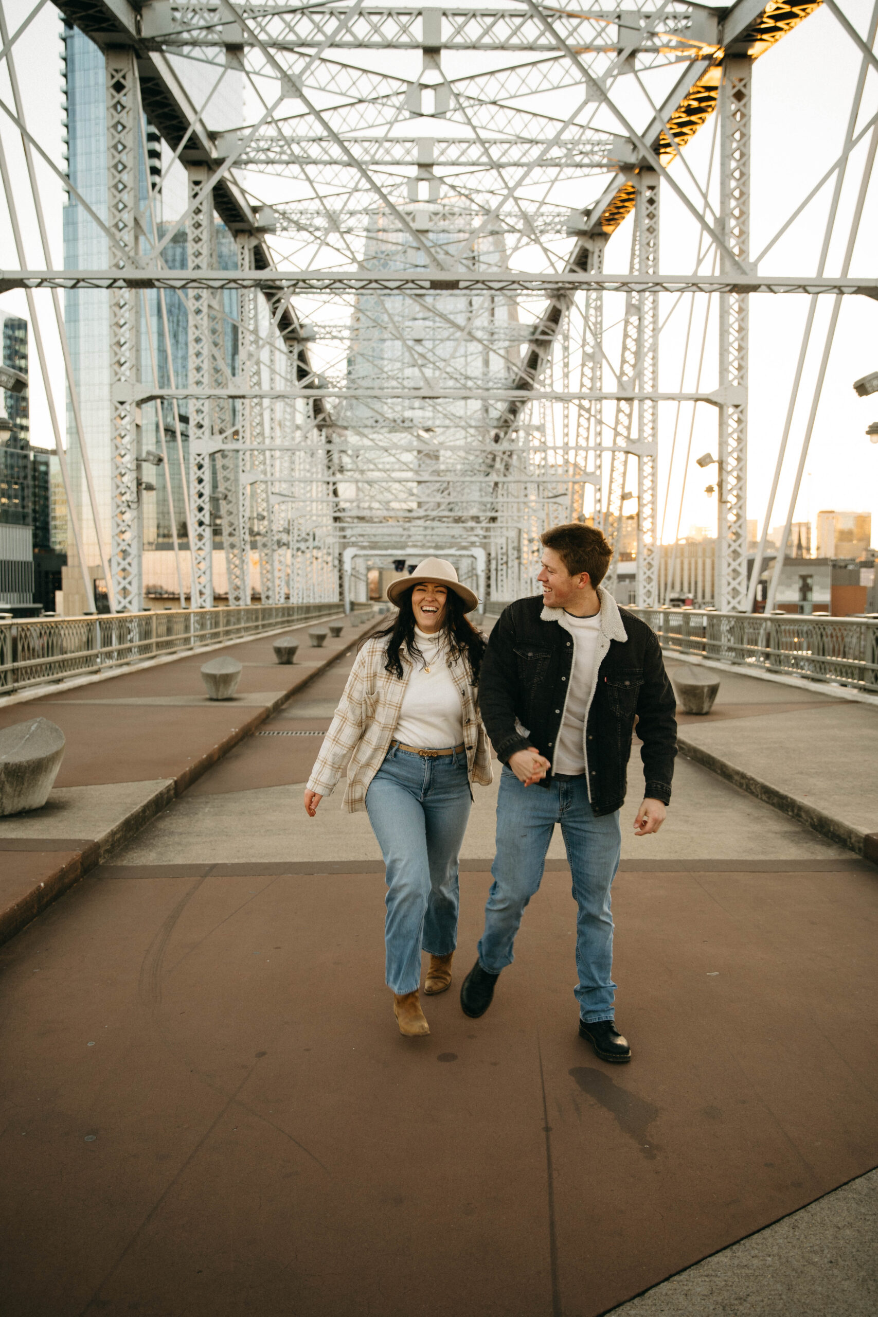 couple during proposal photoshoot at the pedestrian bridge in nashville tennessee